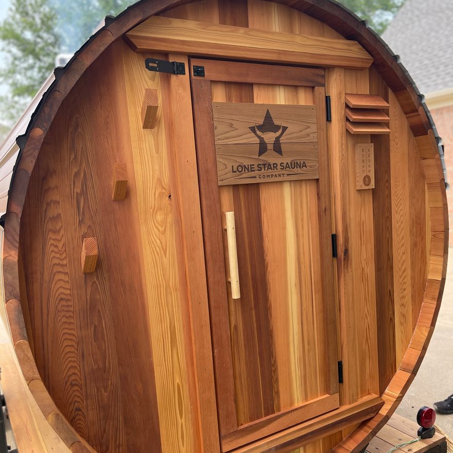 The barrel sauna exterior with the Lone Star Sauna branded cedar door