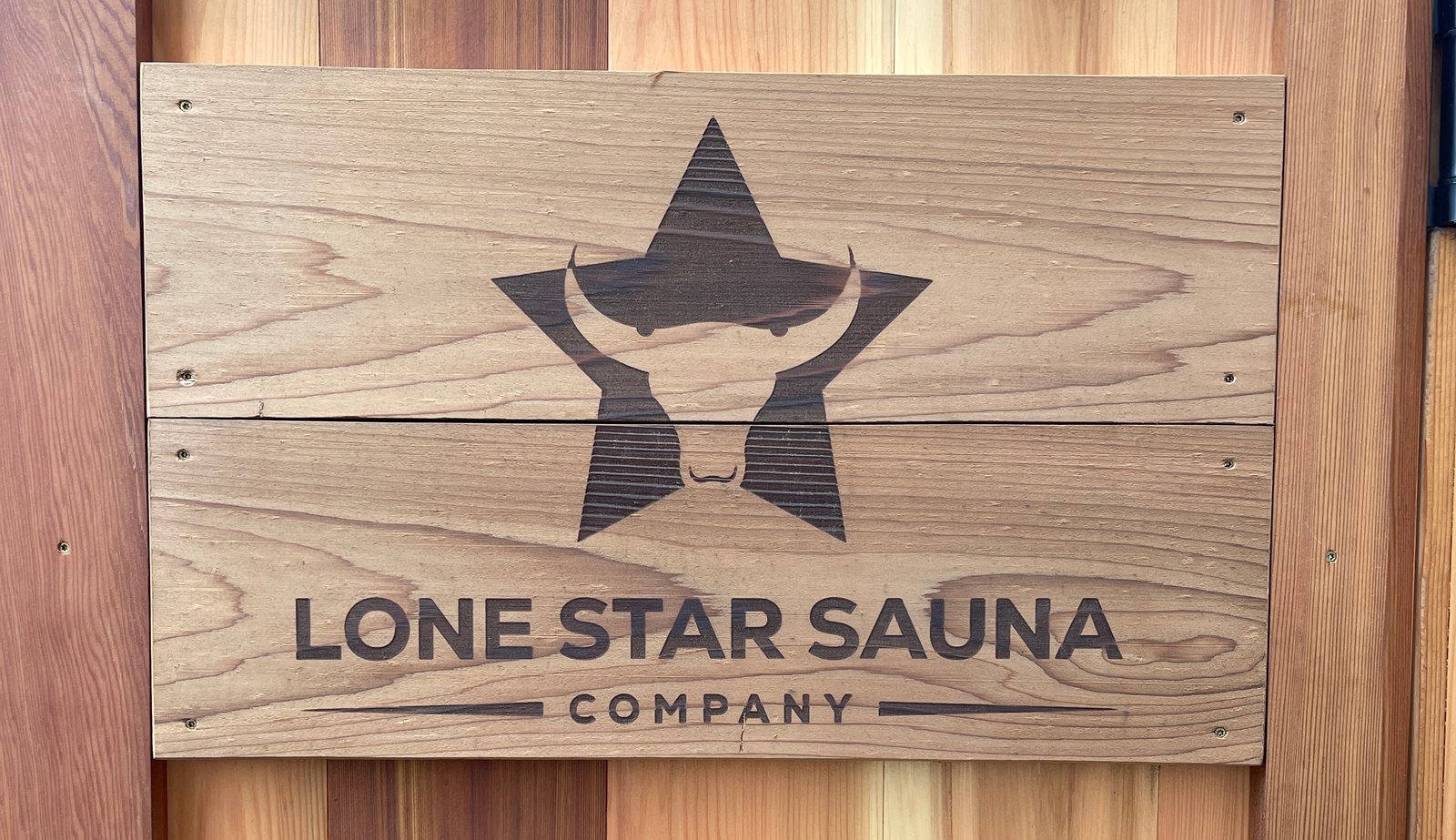 The Lone Star Sauna Company sign burned into cedar